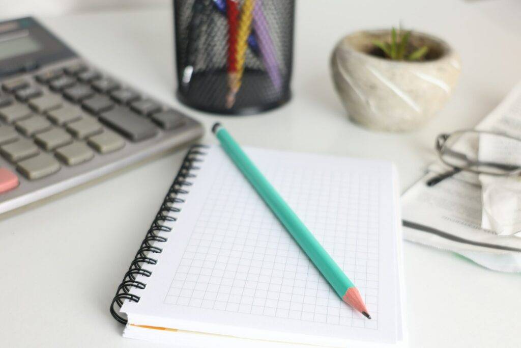 Notebook, pencil and desk items used for practical planning