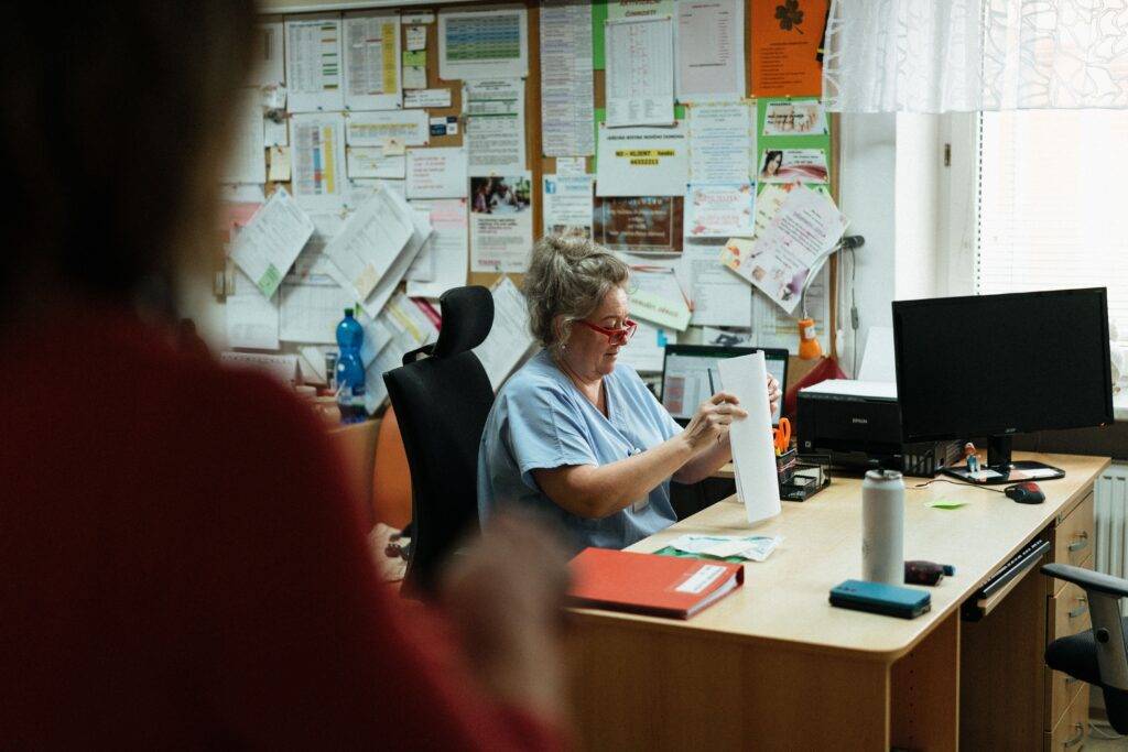 Care professional organising paperwork and documents at a desk
