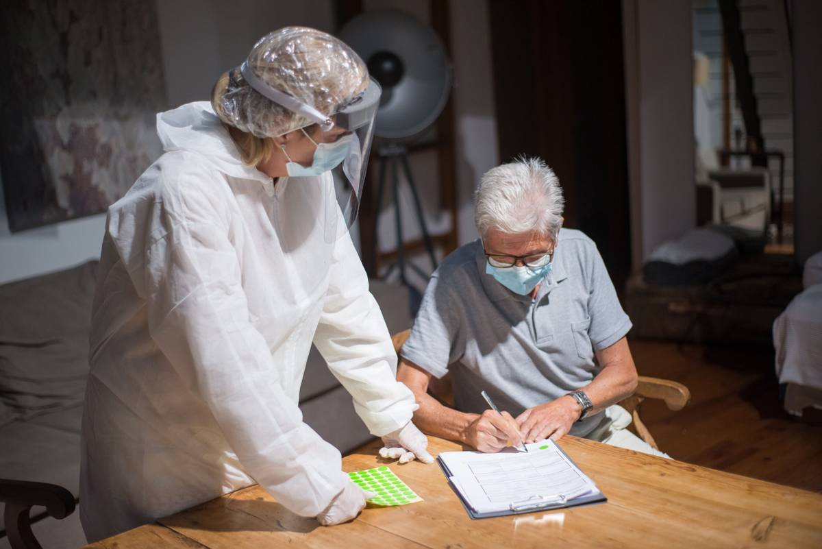 Older adult completing care assessment paperwork with support at home
