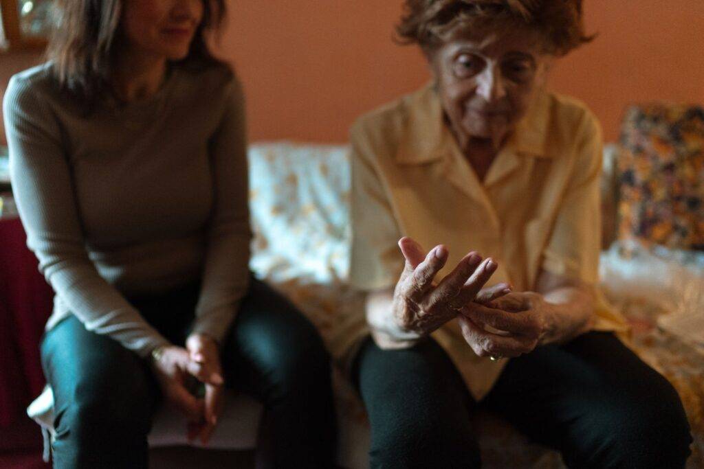 Caregiver talking with an older woman at home during a care handover