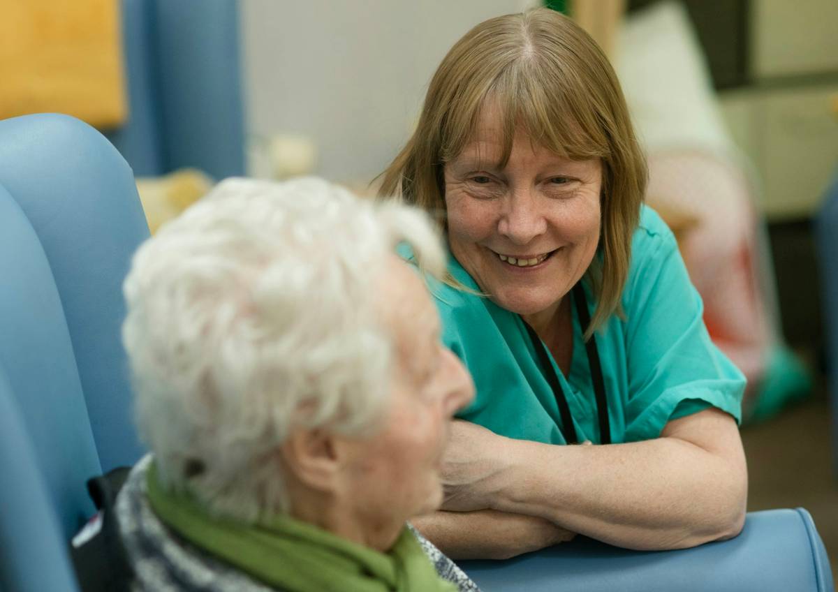 Care professional speaking supportively with an older adult