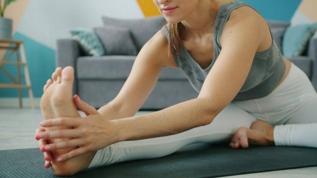 Woman doing a gentle stretching routine at home in the evening