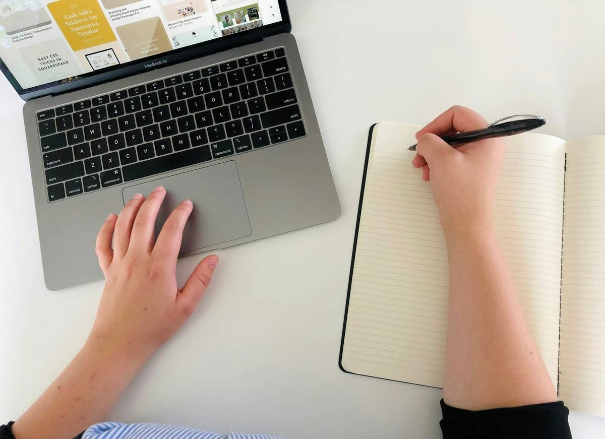 Person using a laptop and notebook to organise a health and care plan
