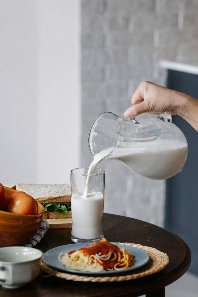 Milk being poured from a jug into a glass