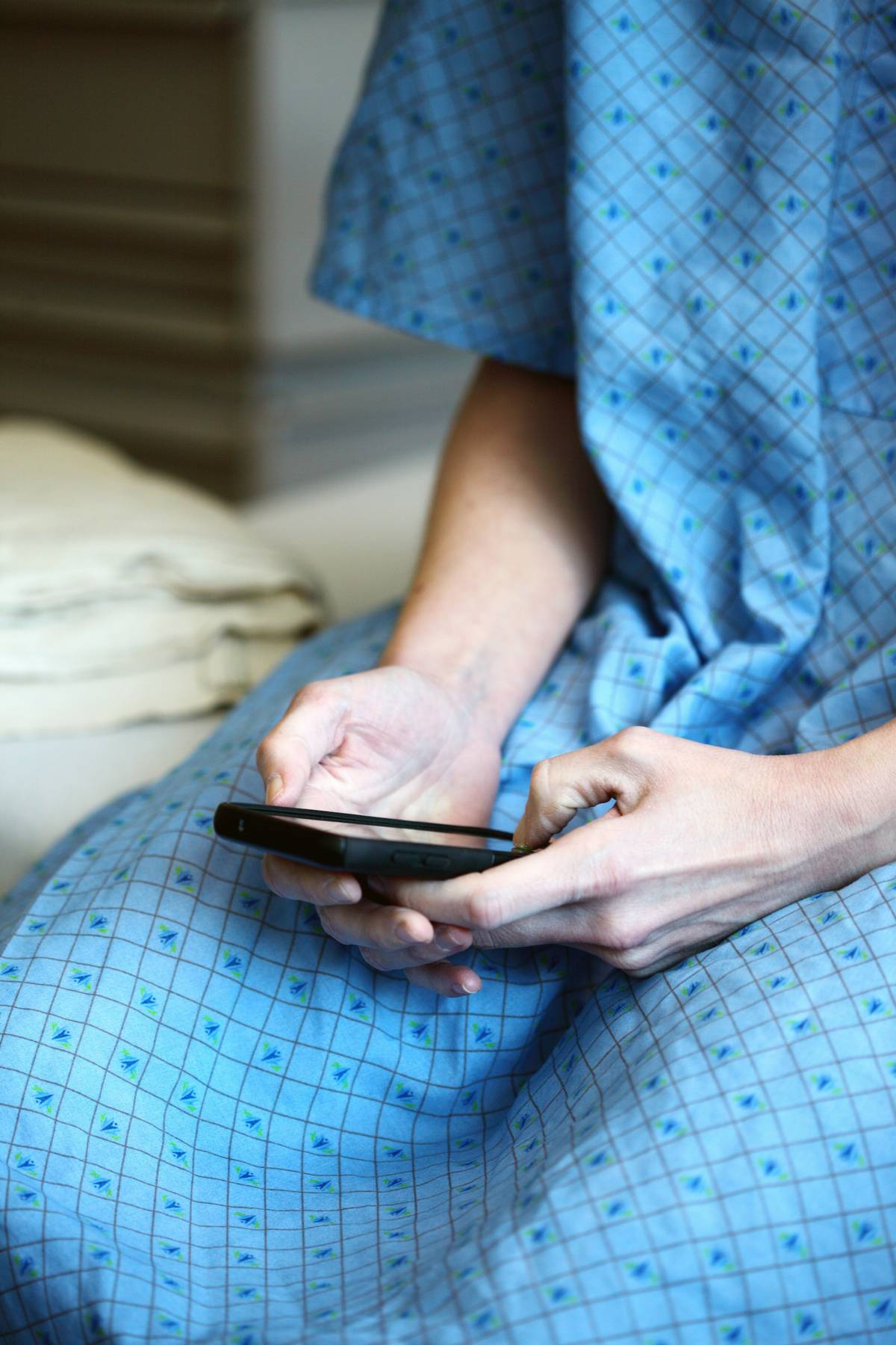 Patient using a smartphone while waiting for hospital care