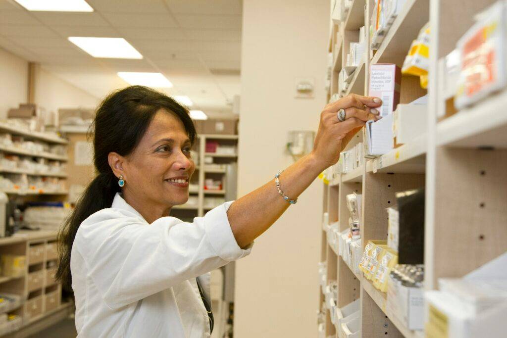 Pharmacist selecting medicine in a community pharmacy