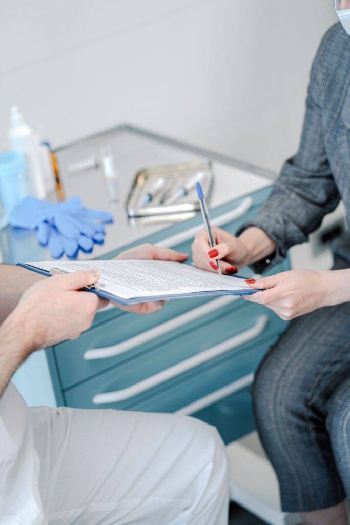 Patient and doctor reviewing medical referral documents in a clinic