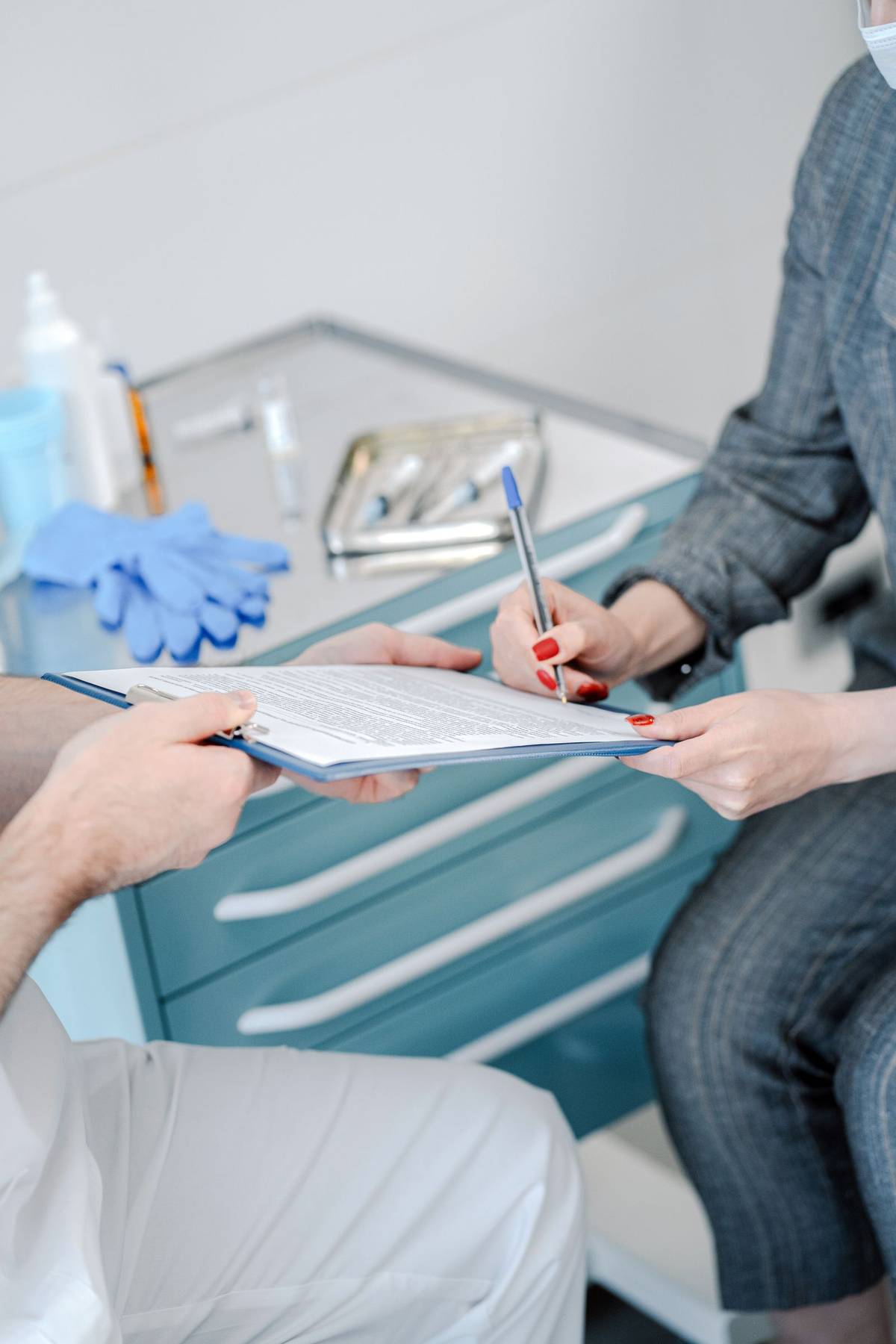 Patient and doctor reviewing medical referral documents in a clinic