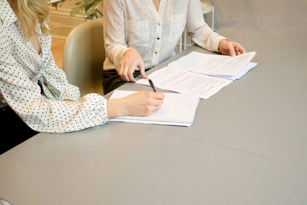 Person reviewing social care financial assessment paperwork with another adult