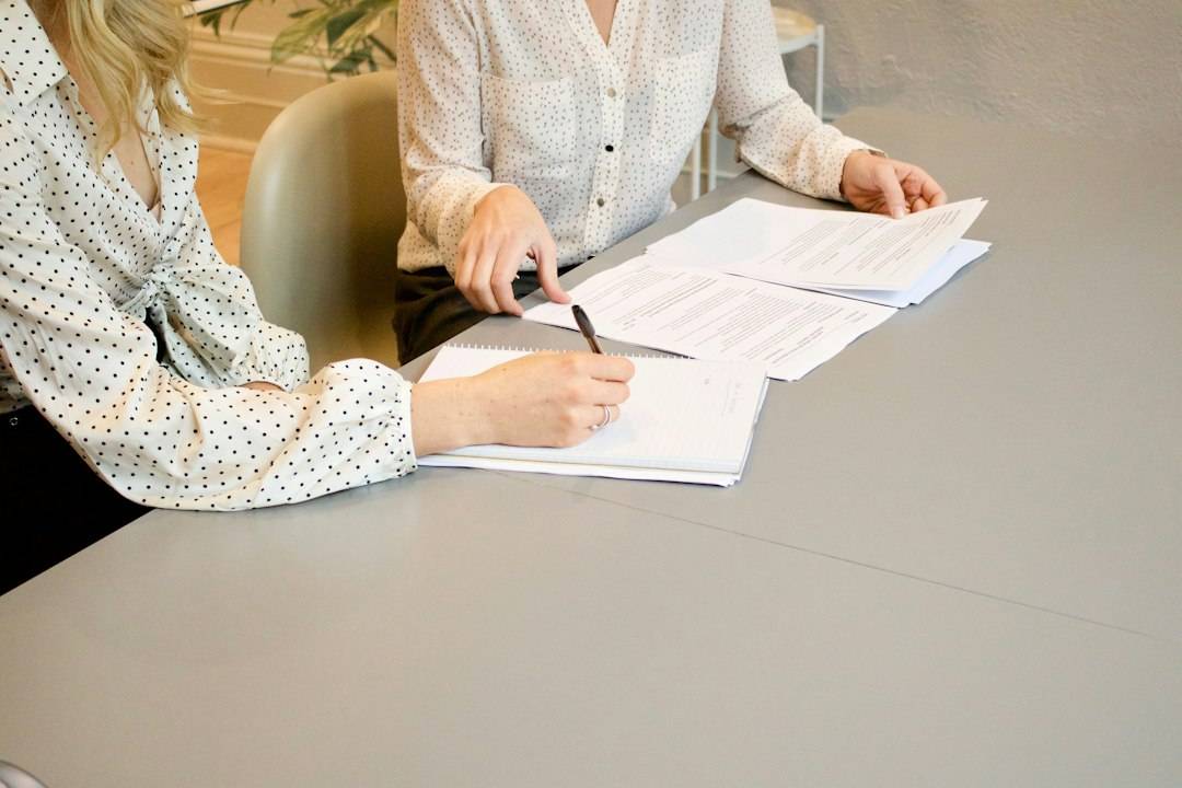 Person reviewing social care financial assessment paperwork with another adult