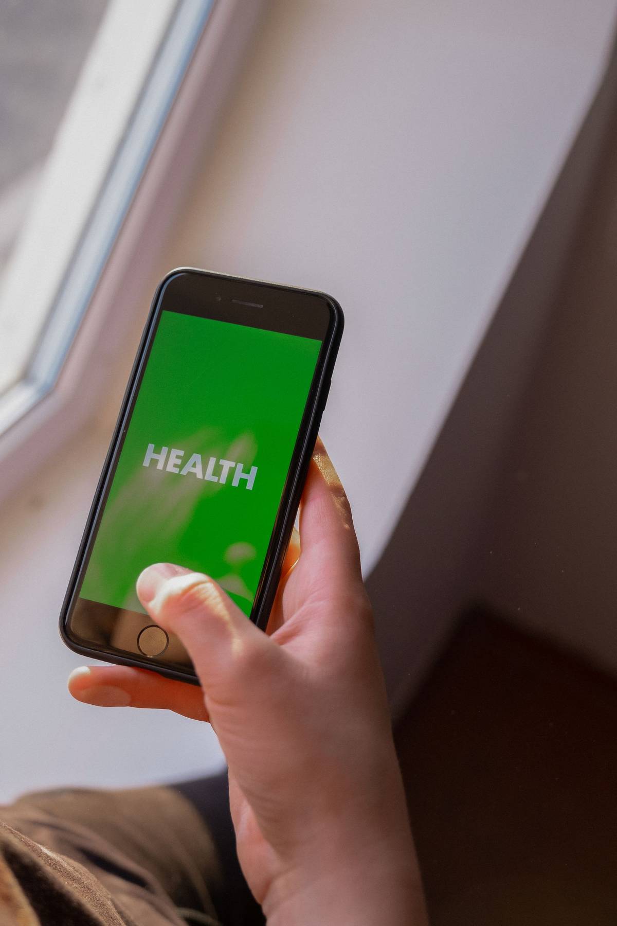 Hand holding a smartphone displaying a health screen