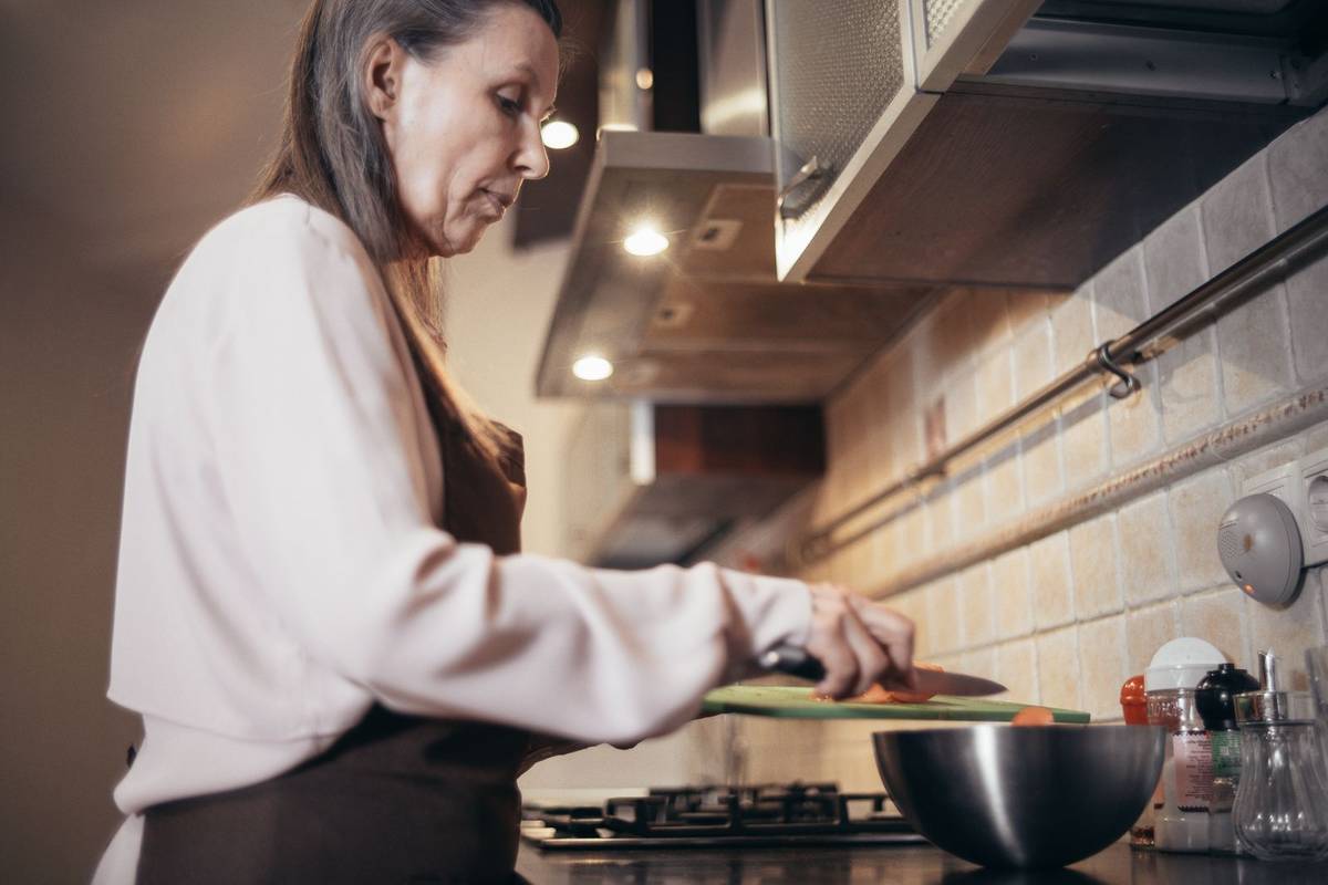 Older woman preparing a meal in a home kitchen
