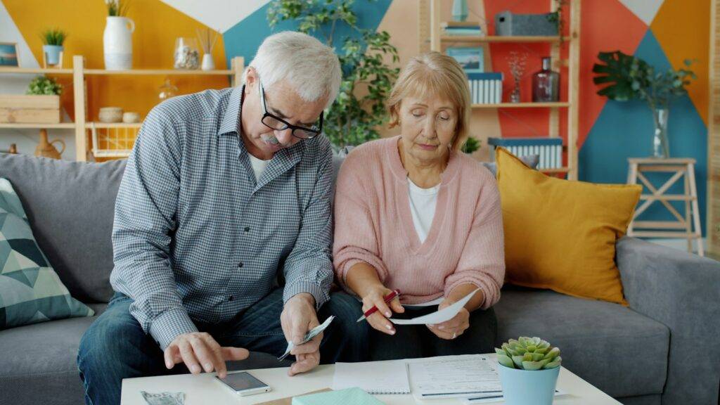 Older couple reviewing household bills and financial paperwork