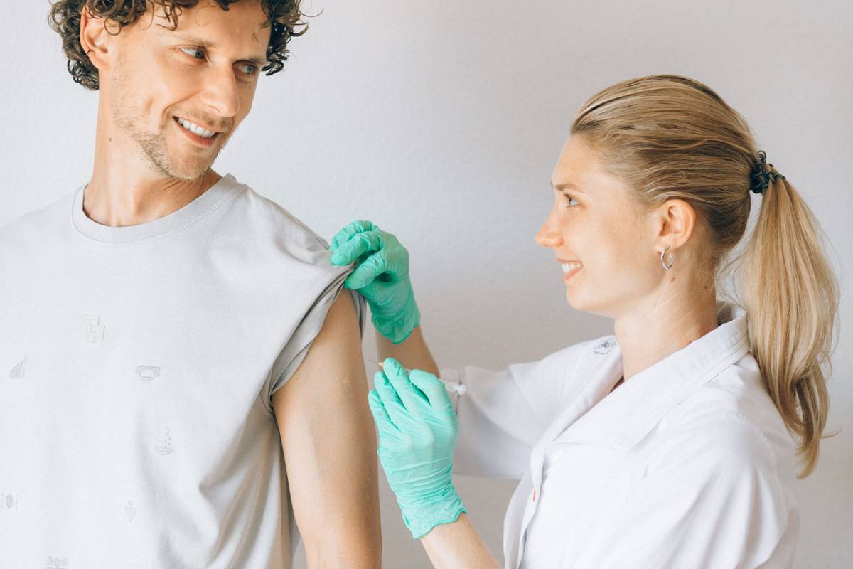 Healthcare professional giving a vaccination to a young adult patient