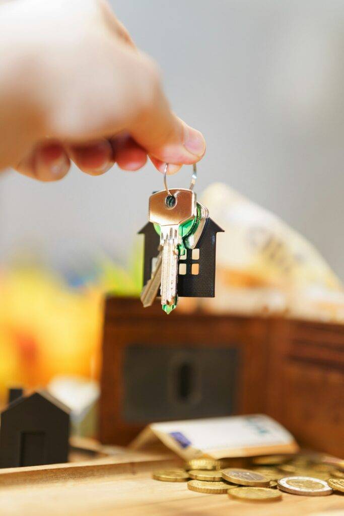 House keys with a home-shaped keyring and money