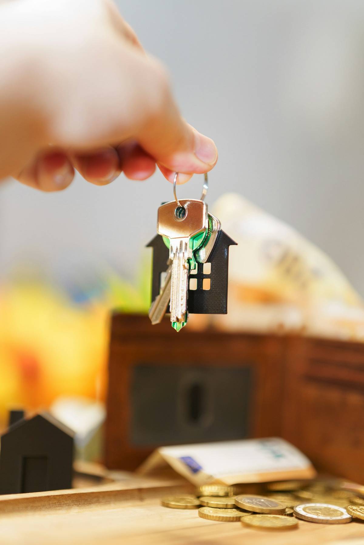 House keys with a home-shaped keyring and money