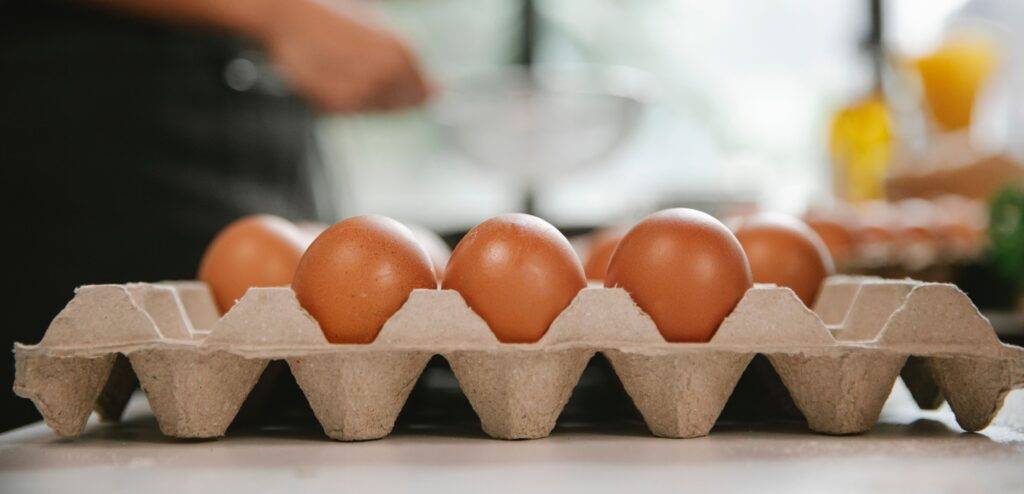 Fresh eggs in a carton on a kitchen counter during food preparation