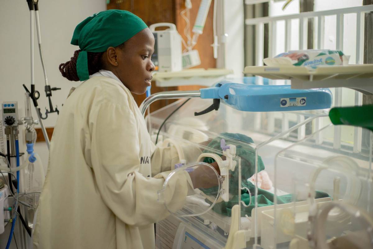 Nurse caring for a newborn baby in a hospital neonatal unit